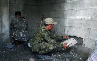 <p><strong>REPAIR</strong>. Soldiers patch up a hole in the house of a Maguindanao farmer they used as observation post during pursuit operation against Islamic State-linked Bangsamoro Islamic Freedom Fighters in Datu Paglas town. <em><strong>(Photo by 33rd IB)</strong></em></p>